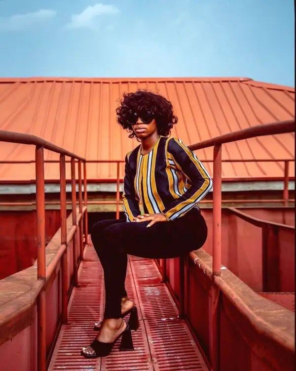 A lady wearing a jacket made from Aso oke